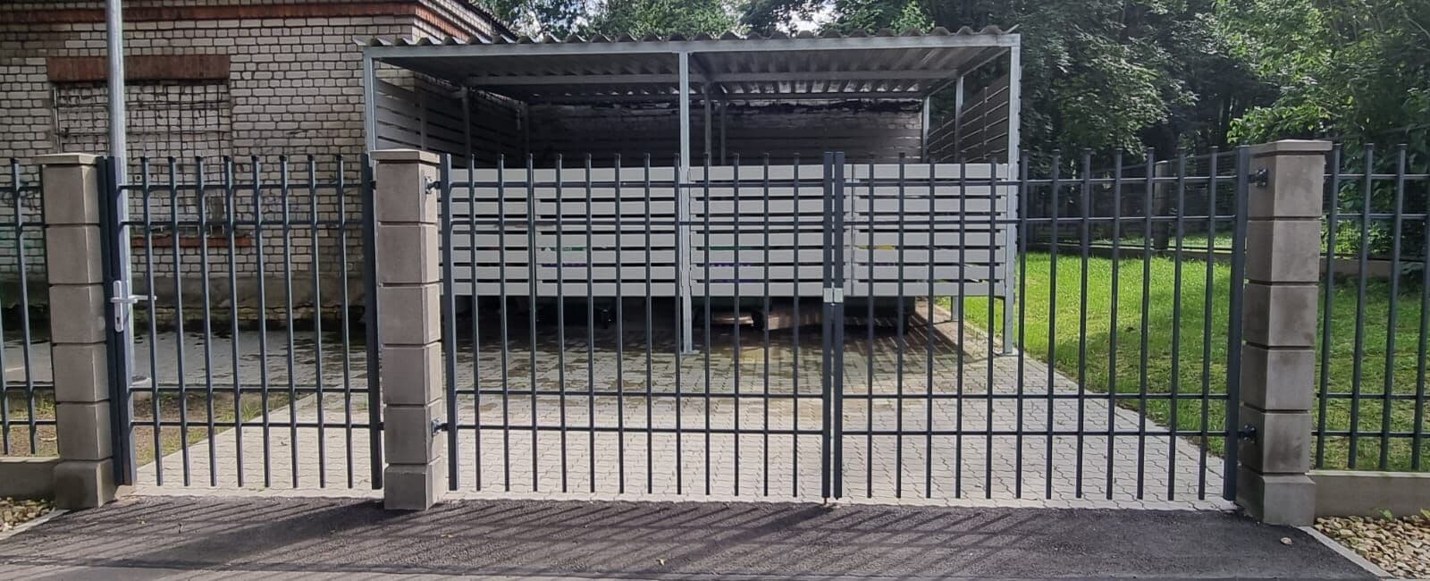 Divvērtņu tērauda vārti un nojume aiz tiem