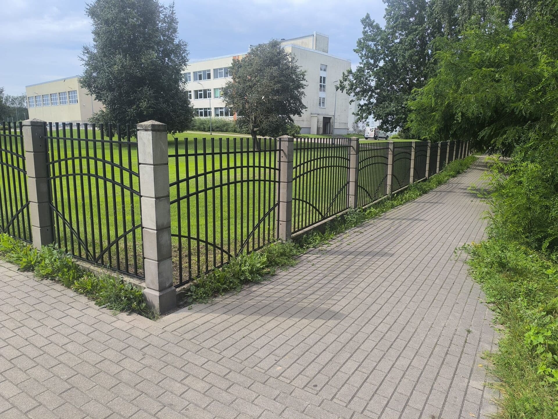 Dekoratīvs tērauda žogs ar arkām gar gājēju celiņu
